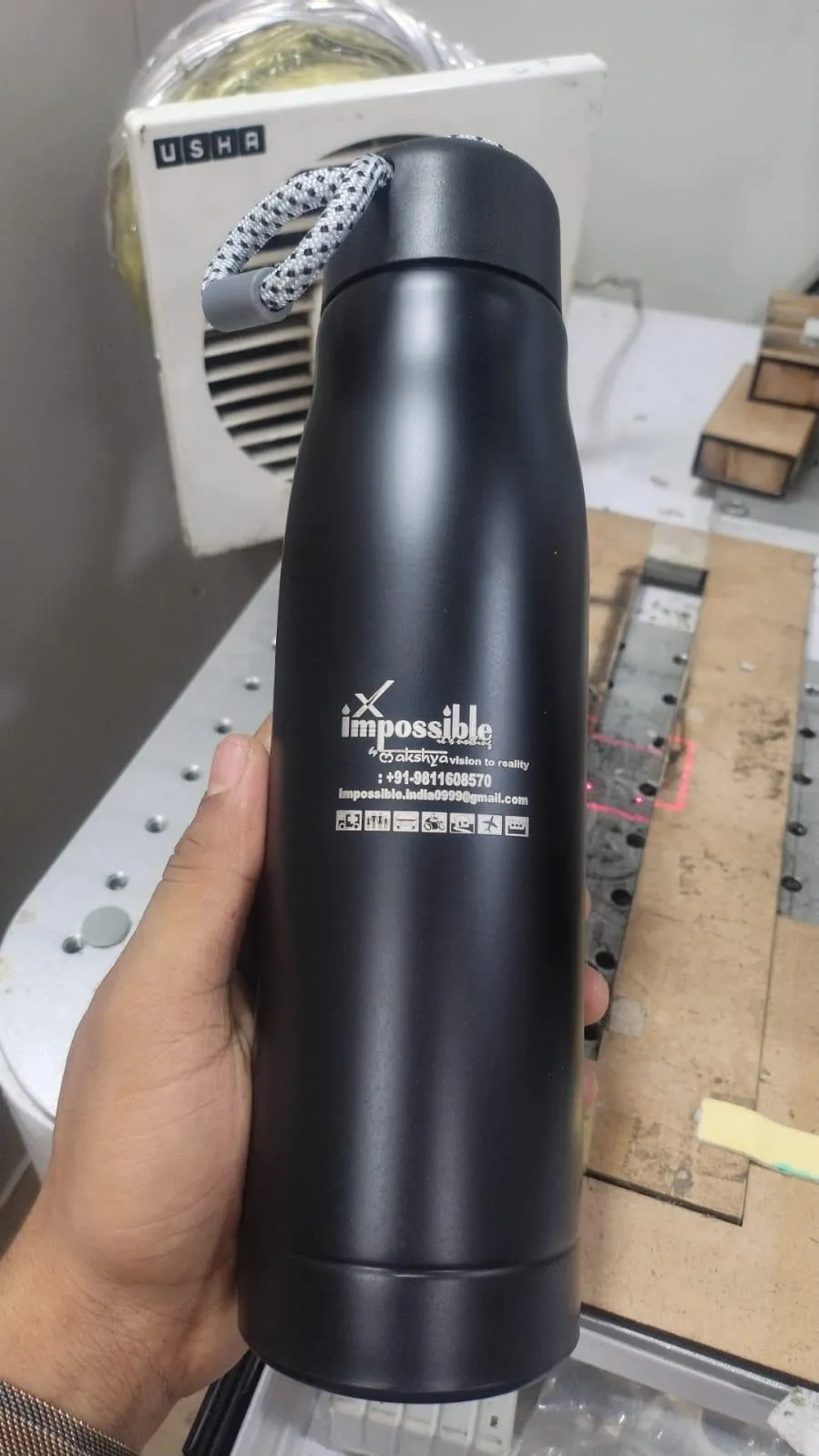Matte black flask with a laser-marked logo and text